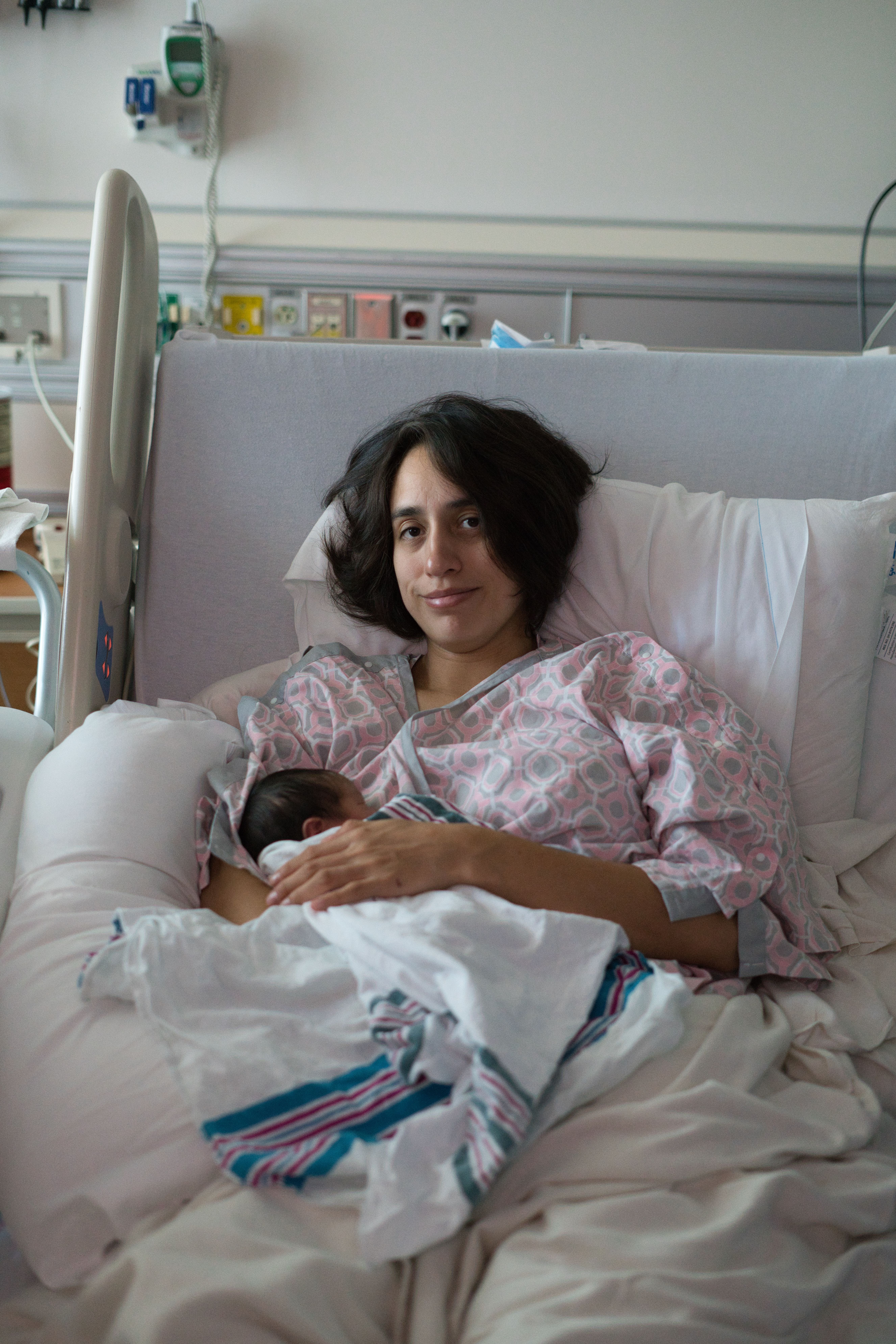 New mother smiling at her newborn in a delivery room