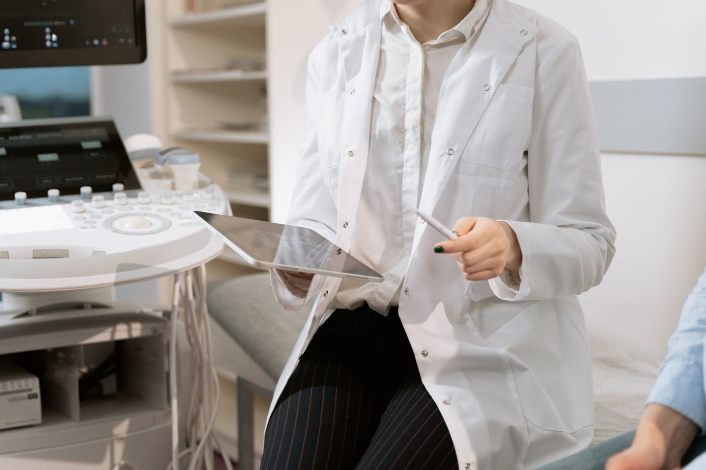 Clinician with a tablet beside an ultrasound machine